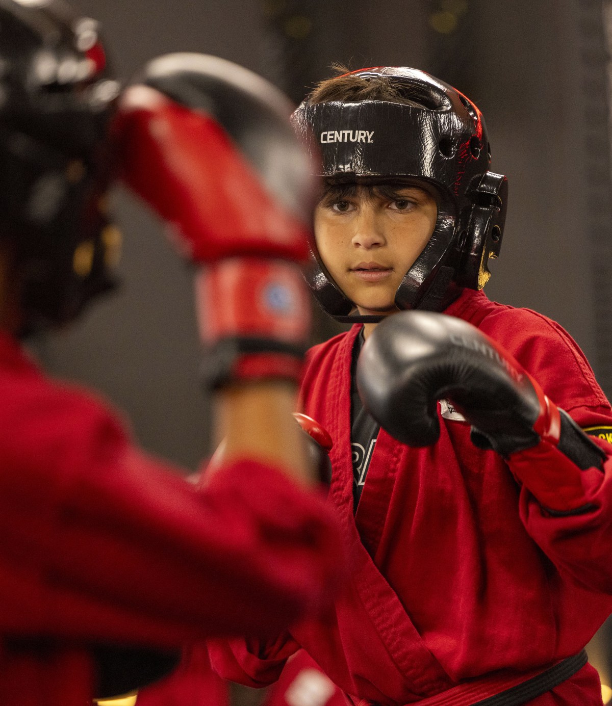 Young martial artist in guard with headgear at XFIT
